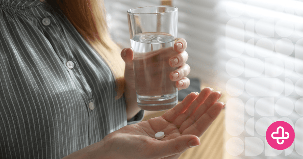 Person holding a glass of water and a pill, representing abortion pill side effects and the medication abortion experience.
